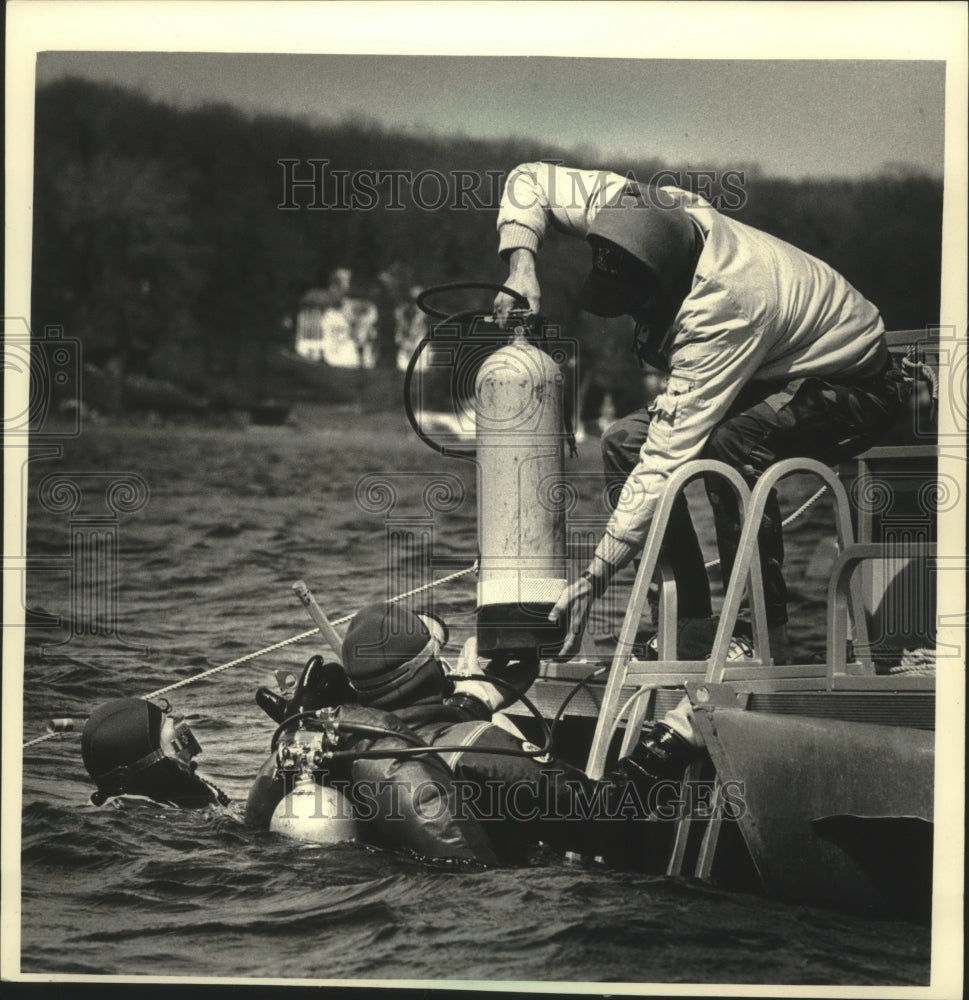 1988 Press Photo Diver is handed oxygen tank from Dive USA member, Pewaukee Lake- Historic Images