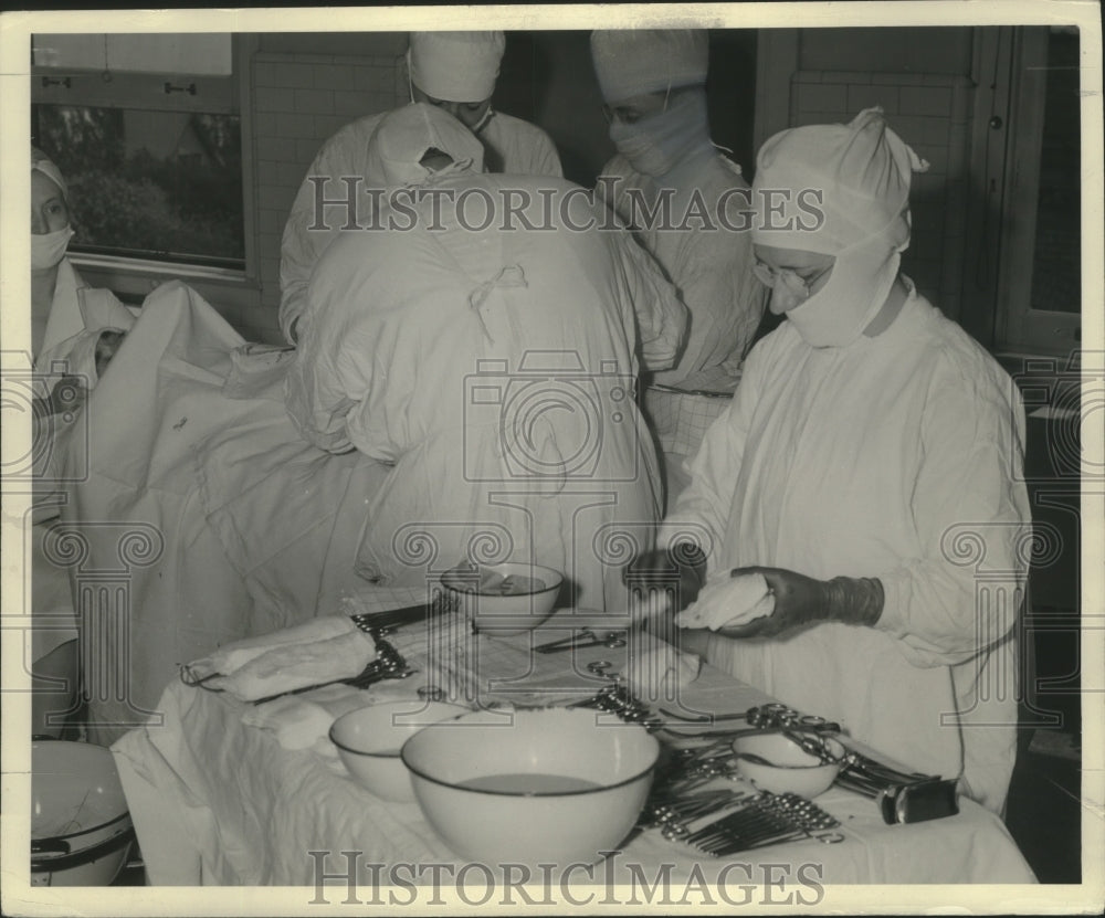 1939 Press Photo Doctors in surgery with operation tools. - mjb81395- Historic Images