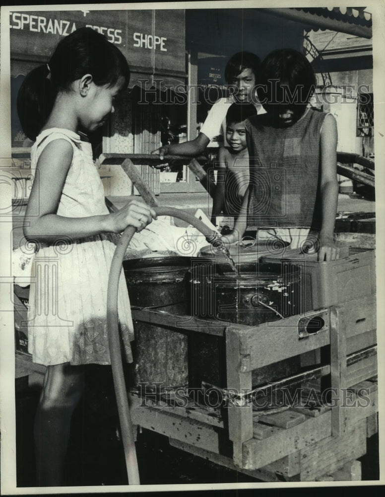 1968 Press Photo Girls filling water cans from a nearby well Manila, Philippines- Historic Images