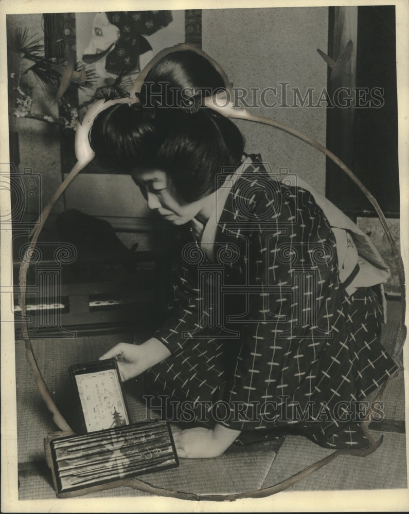 1929 Press Photo Young Japanese lady on her knees, presents restaurant bill- Historic Images