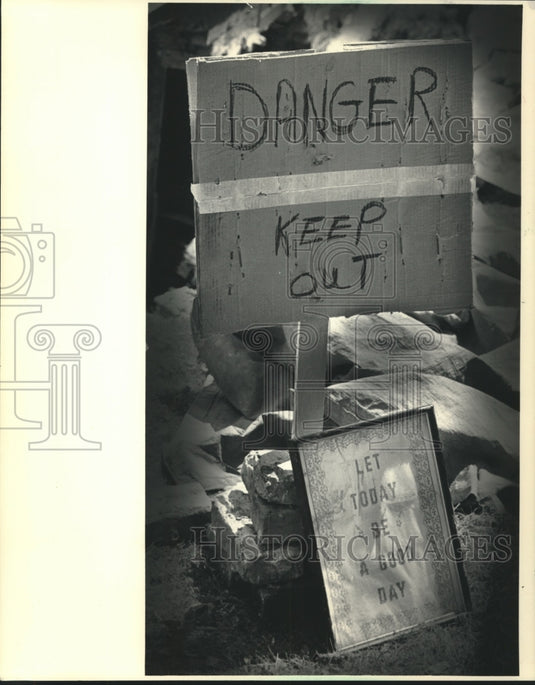 1986 Press Photo An optimist's sign leaned against a warning, Milwaukee- Historic Images