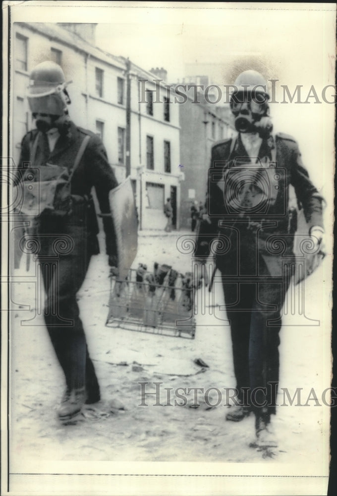 1969 Press Photo Police officers wearing gas masks carry fire bombs-Londonderry- Historic Images