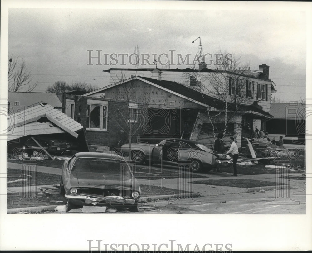 1974 Press Photo Couple stood near car outside tornado damaged homes, Wisconsin- Historic Images