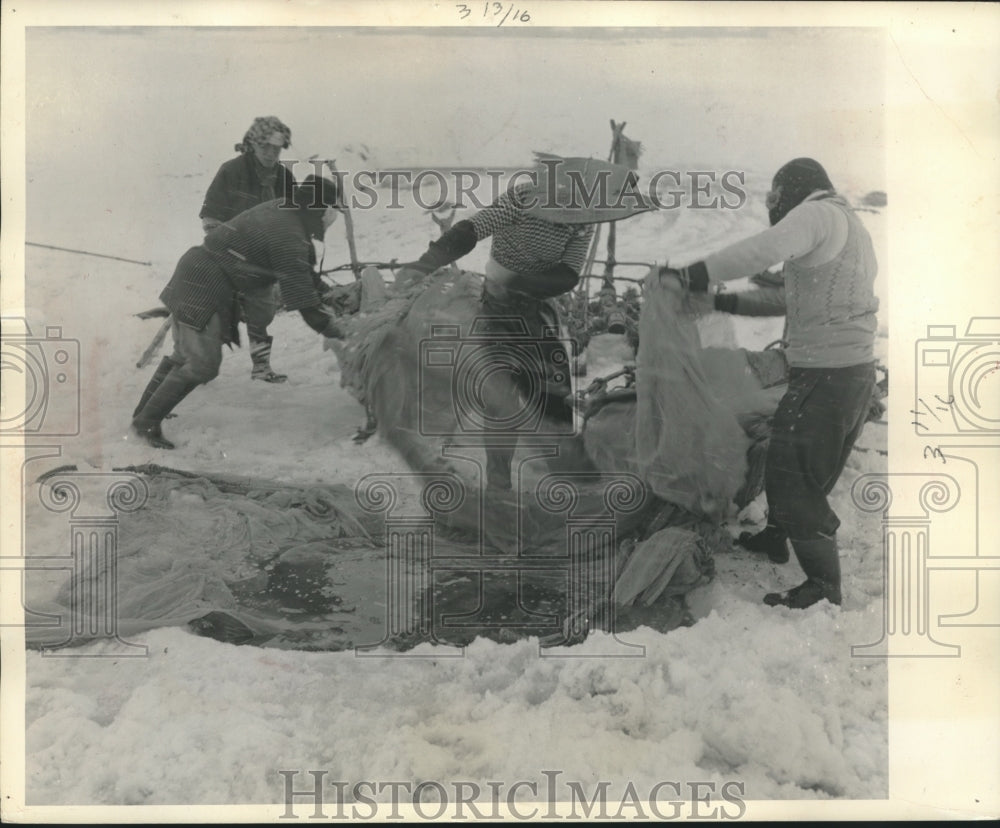 1957 Press Photo Japanese ice fishing industry, men work fast to unload nets- Historic Images