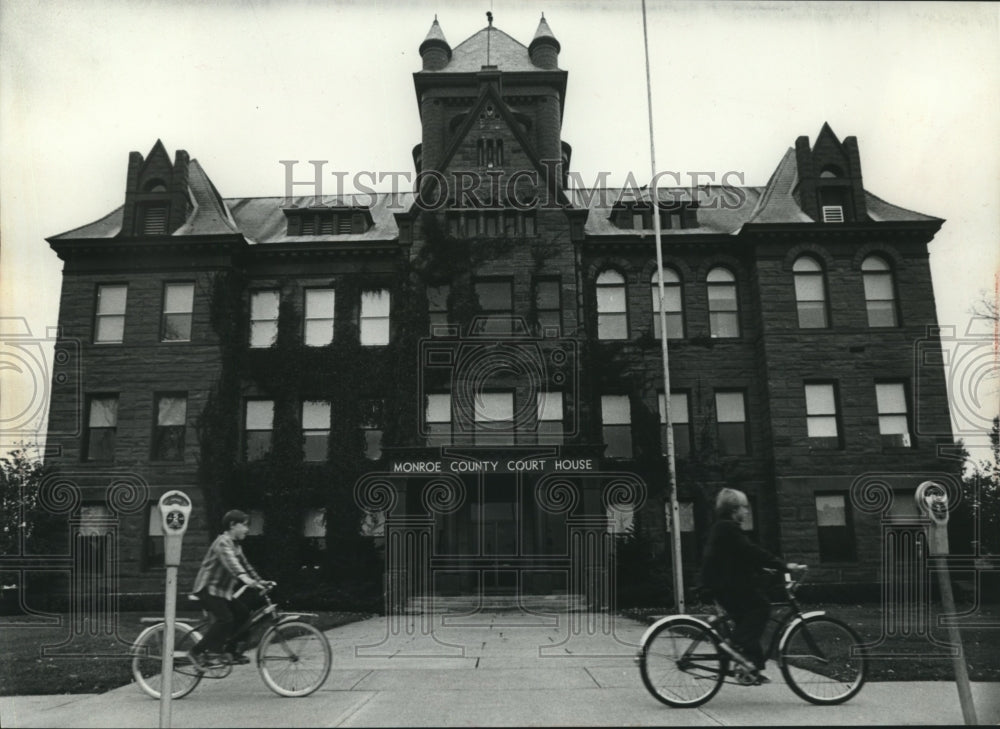 1974 Press Photo Boys ride bikes past Monroe County Courthouse, Sparta Wisconsin- Historic Images