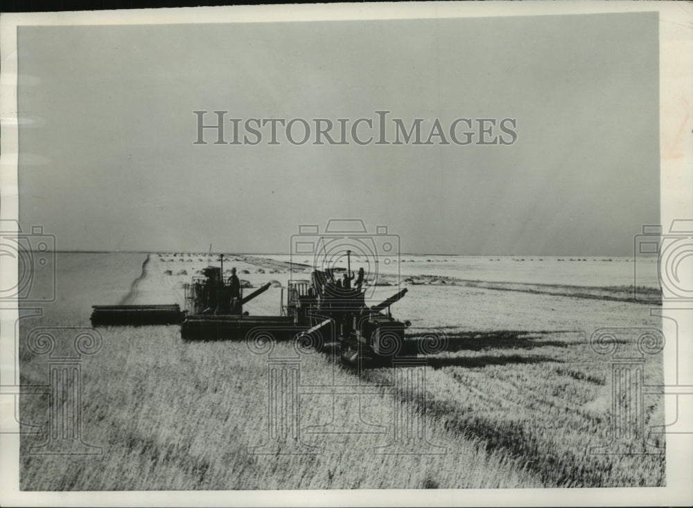 1954 Press Photo Men on harvesters in wheat field, Kustanai, Russia state farm