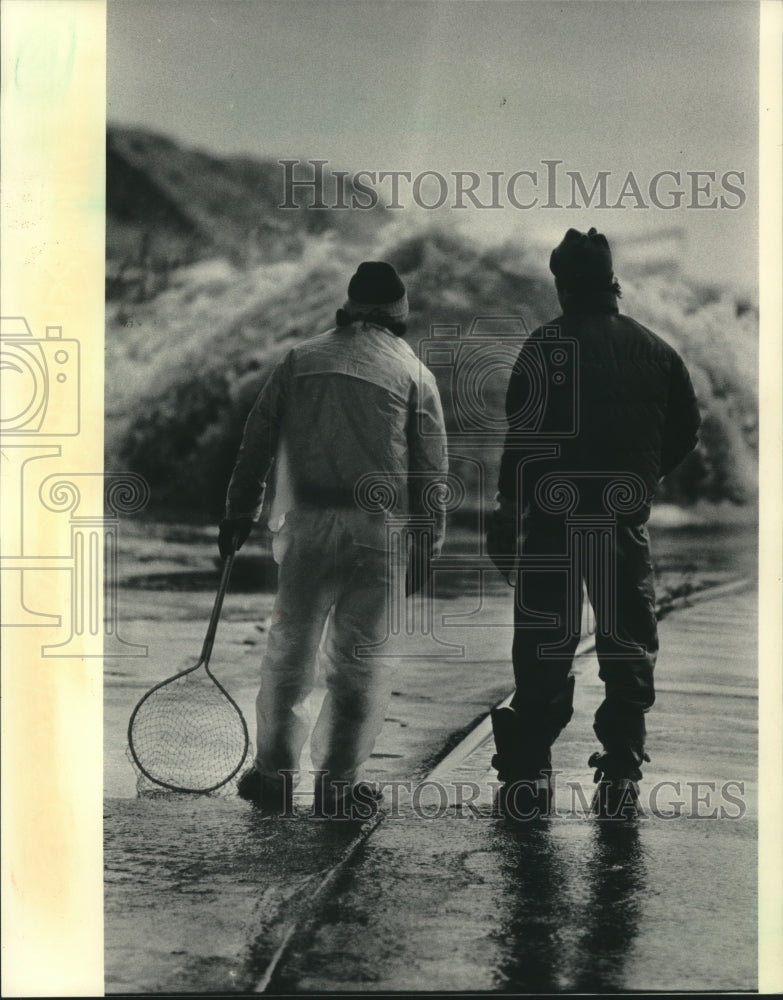 1963 Press Photo Fishermen on Jones Island waiting for wave surges to bring fish- Historic Images