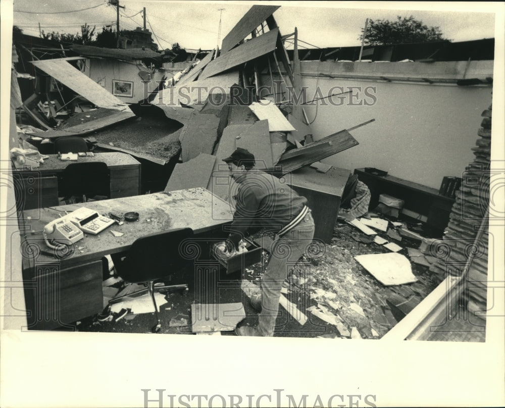 1987 Press Photo Randy Wolf assesses damage at office in Kenosha after windstorm