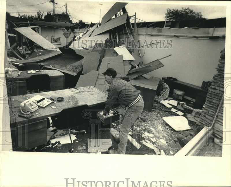 Load image into Gallery viewer, 1987 Press Photo Randy Wolf assesses damage at office in Kenosha after windstorm
