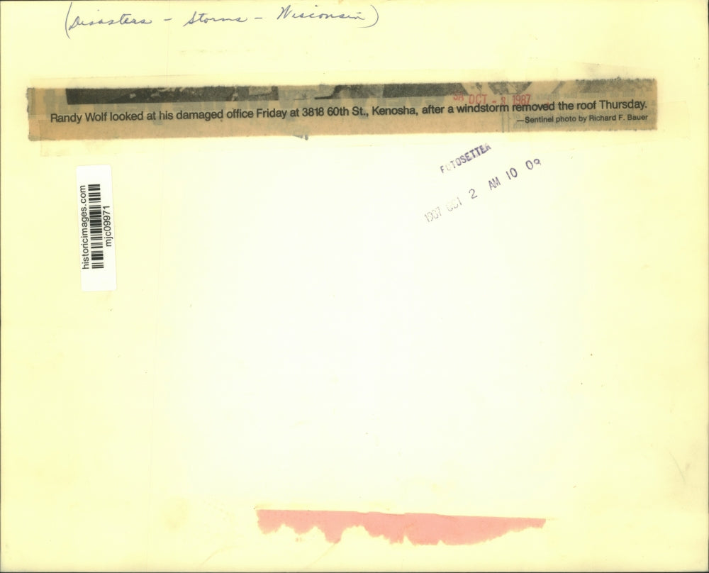 1987 Press Photo Randy Wolf assesses damage at office in Kenosha after windstorm