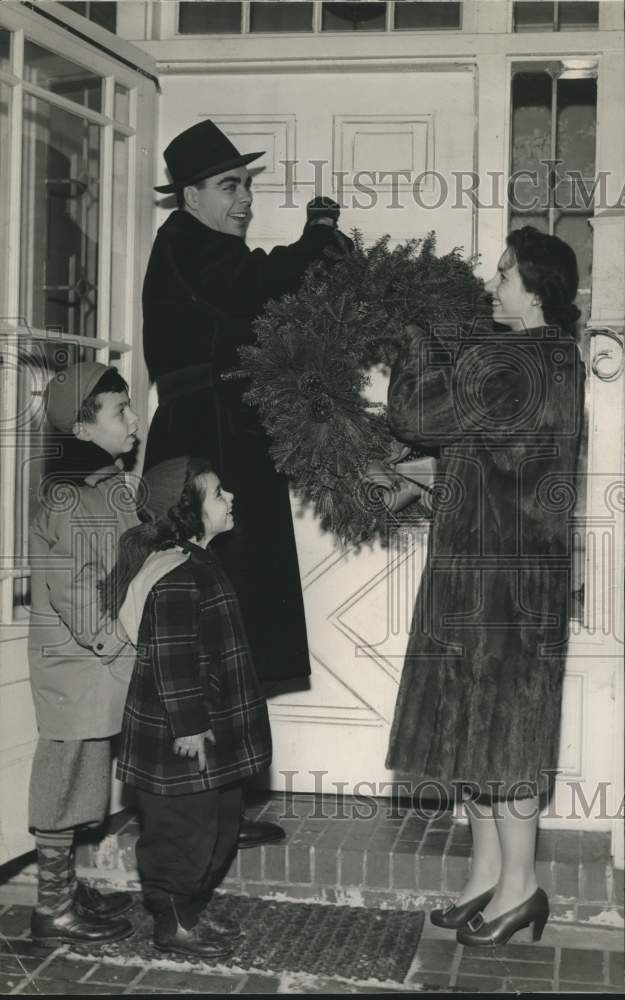 Load image into Gallery viewer, 1942 Press Photo Mr. &amp; Mrs. Morton R. Spence hang wreath with Sukie &amp; Morton Jr.
