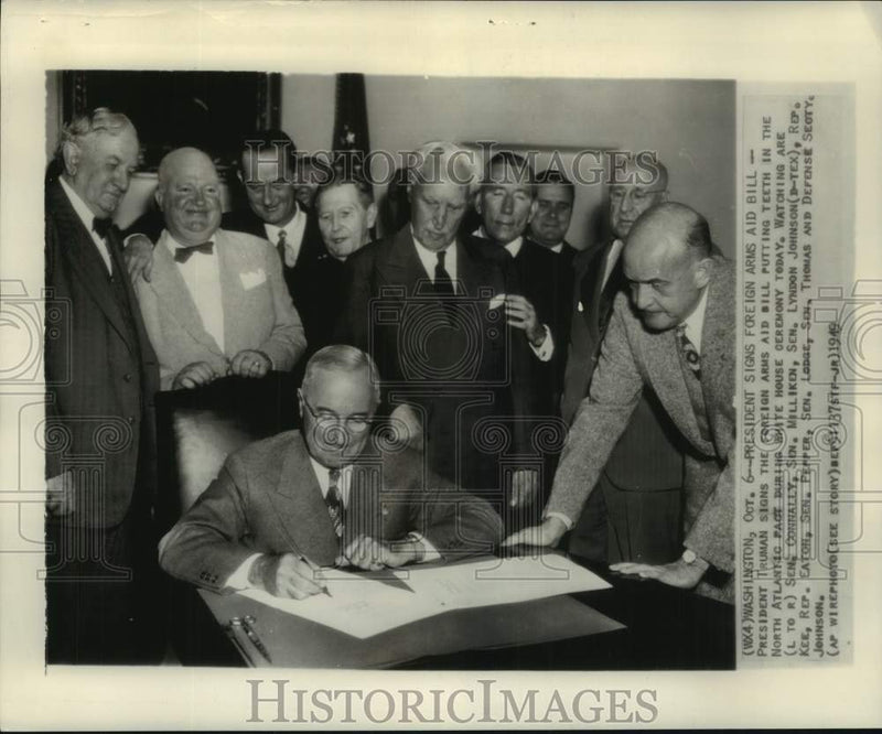 Load image into Gallery viewer, 1949 Press Photo Pres. Truman signs Foreign Arms Aid Bill as Senators look on.
