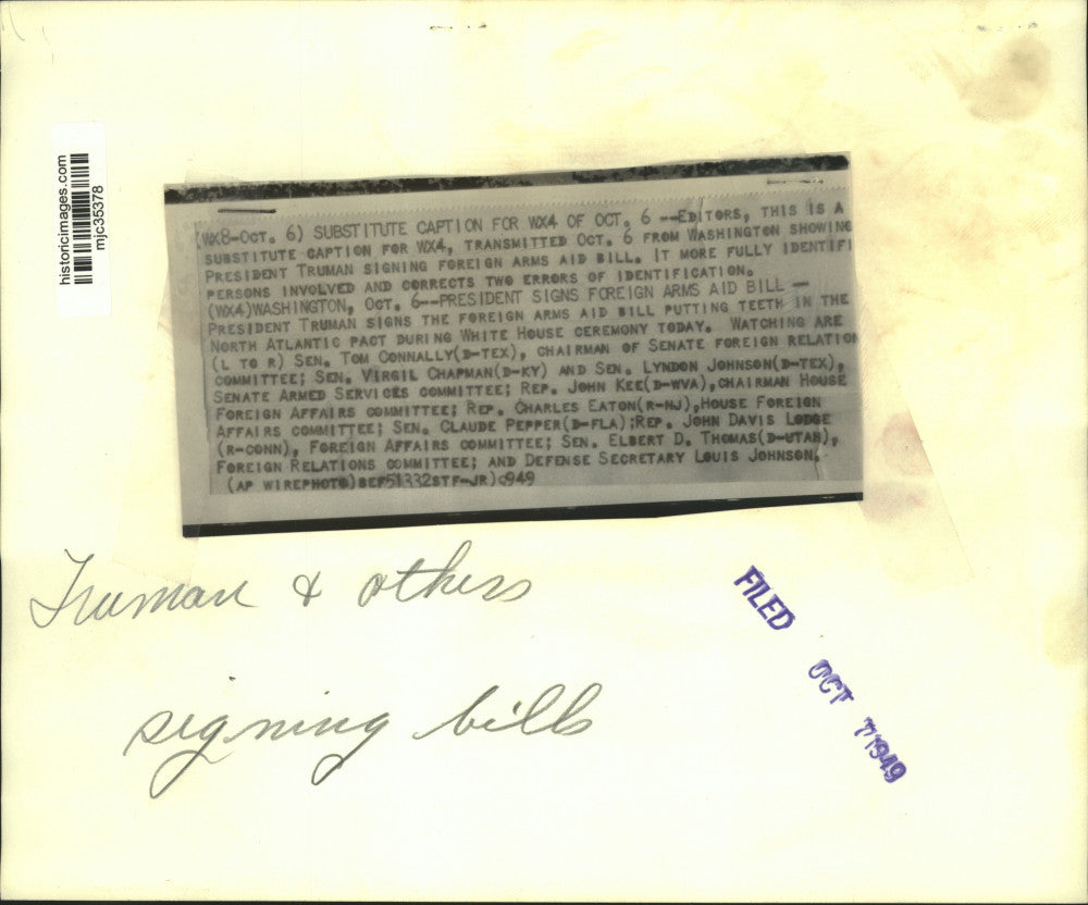 1949 Press Photo Pres. Truman signs Foreign Arms Aid Bill as Senators look on.