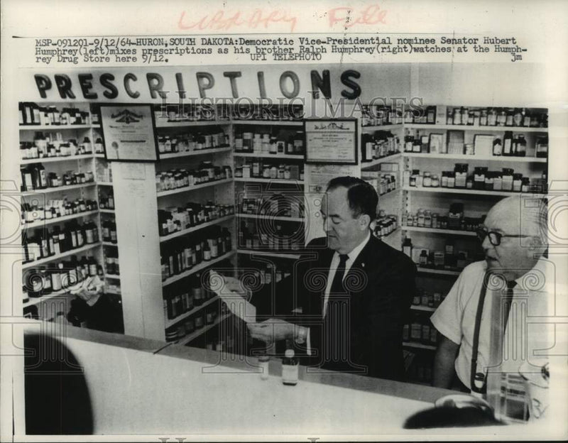 Load image into Gallery viewer, 1964 Press Photo Senator Hubert Humphrey behind pharmacy counter, South Dakota

