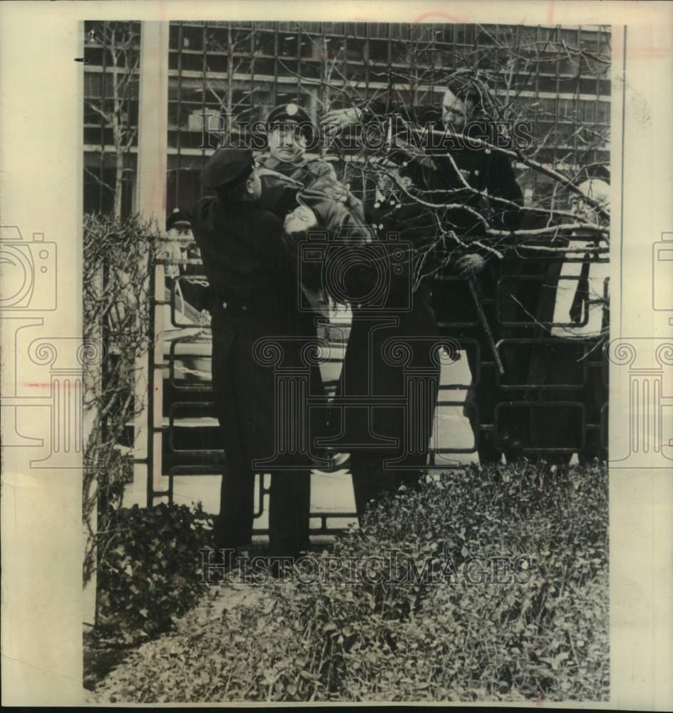 1964 Press Photo Officers lift a woman demonstrator over fence near UN, New York