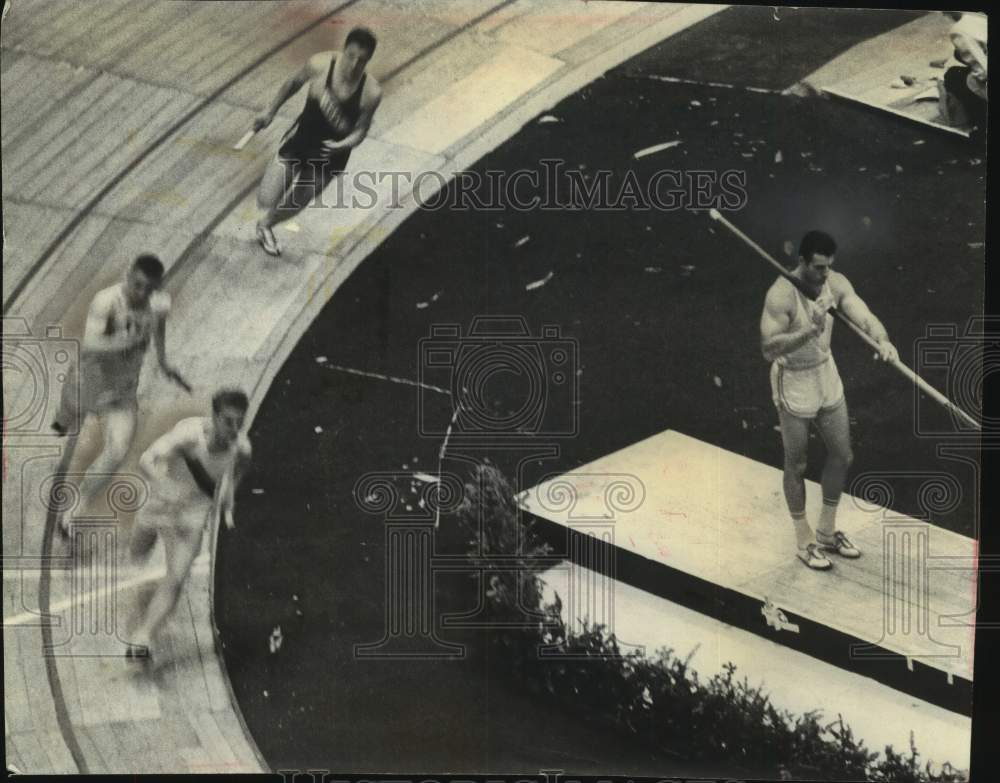 1961 Press Photo Runners race by pole vaulter at Milwaukee Journal track meet.- Historic Images