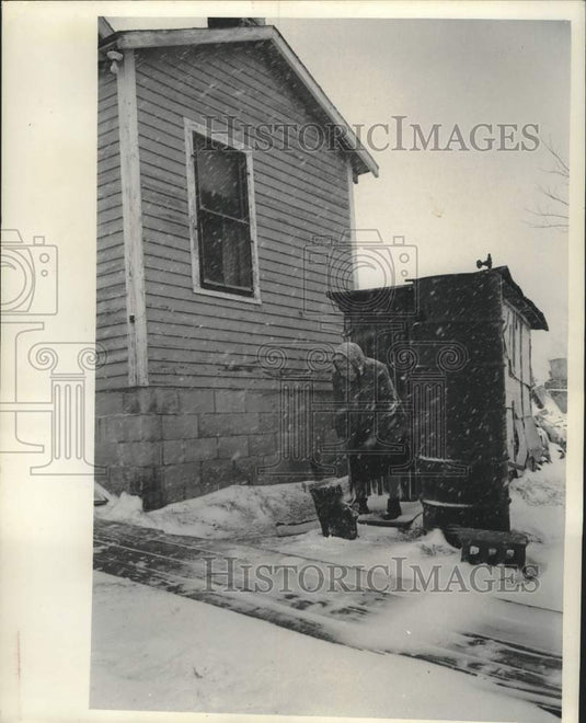 1965 Press Photo Mrs. Moshoquit chopped wood as snow swirled around her- Historic Images
