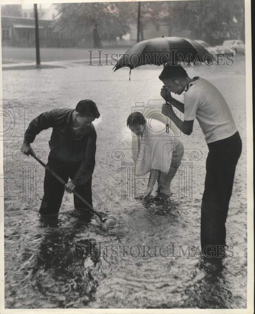 1959 Press Photo Men try to open a sewer on a flooded street in Milwaukee- Historic Images