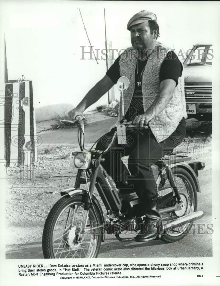 1987 Press Photo Dom DeLuise actor rising a bike and staring in "Hot Stuff."- Historic Images