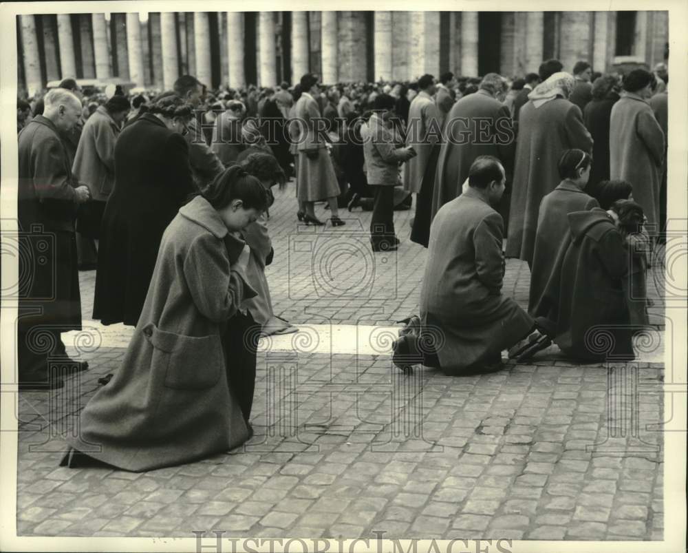 1957 Press Photo Pilgrims kneel in prayer in Vatican City square, Rome, Italy