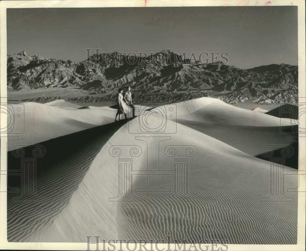 1950 Press Photo Visitors on dunes near mountains in Death Valley, California- Historic Images