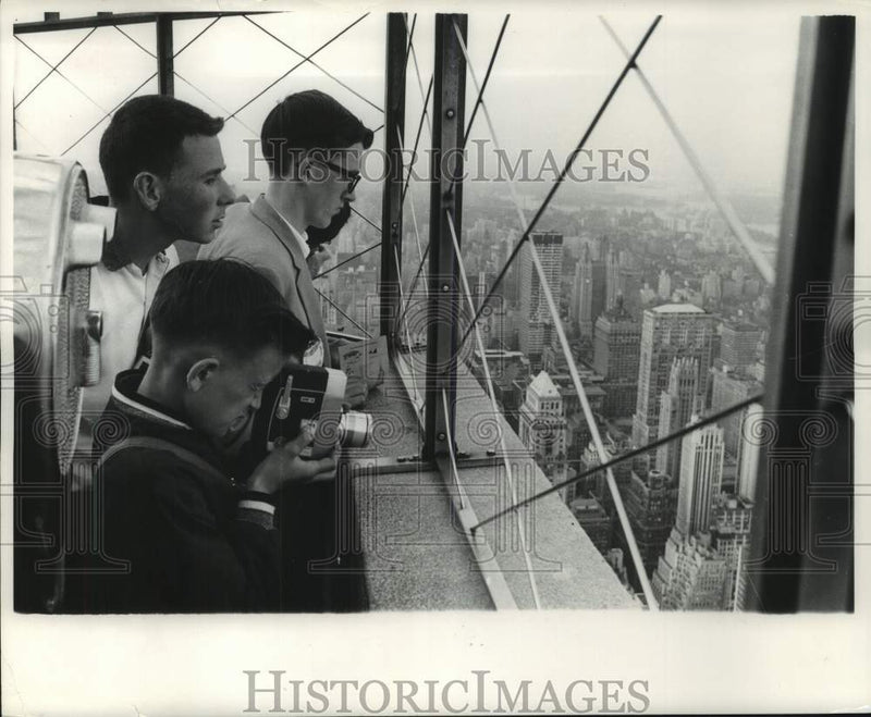 Load image into Gallery viewer, 1961 Press Photo Milwaukee Journal Newsboys peer out at a city of skyscrapers
