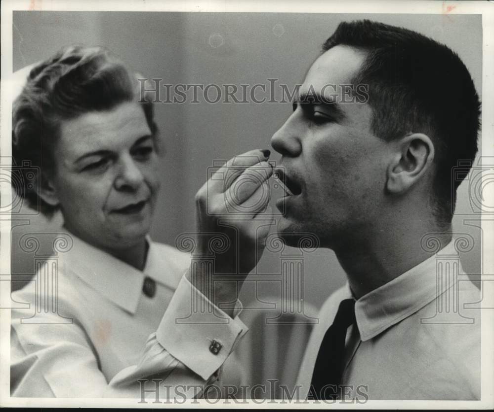 1965 Press Photo The Milwaukee Journal Nurse Peg Hubing treats a worker, WI