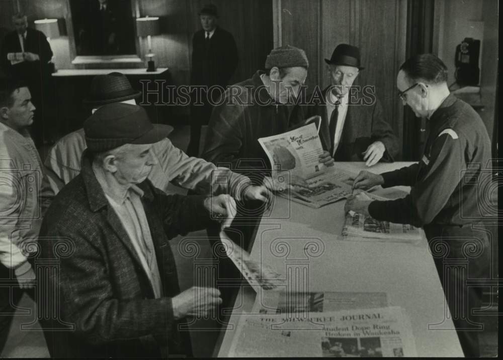 1967 Press Photo Men reading the last copies of the newspaper Peach in lobby, WI- Historic Images