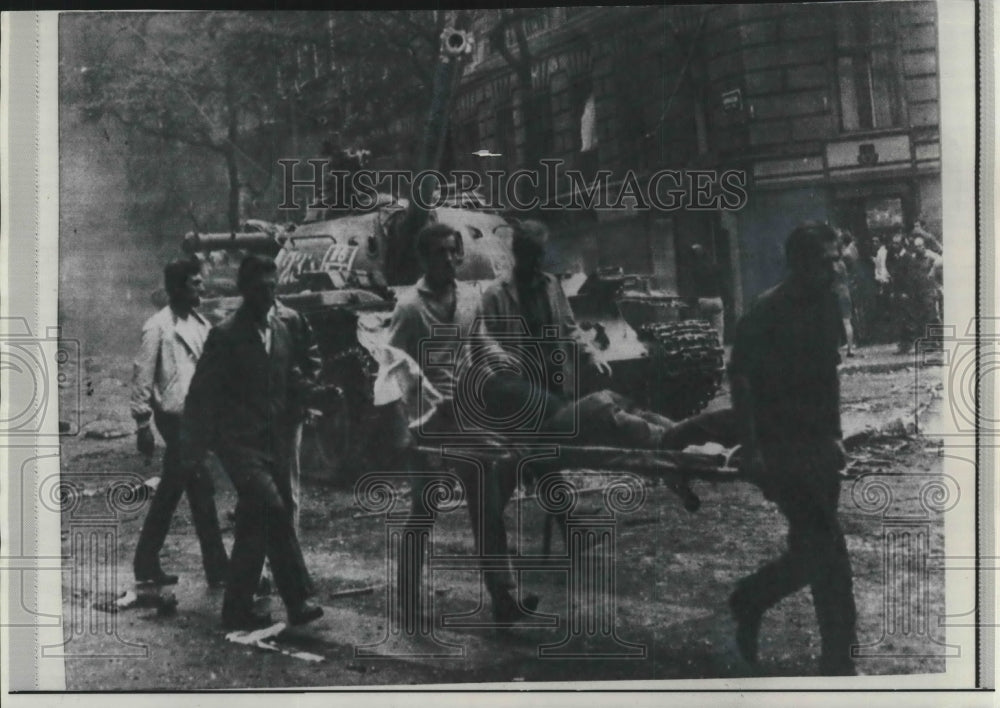 1968 Press Photo Young Czechs carry wounded comrade on street in Czechoslovakia