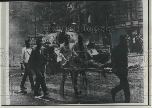 1968 Press Photo Young Czechs carry wounded comrade on street in Czechoslovakia