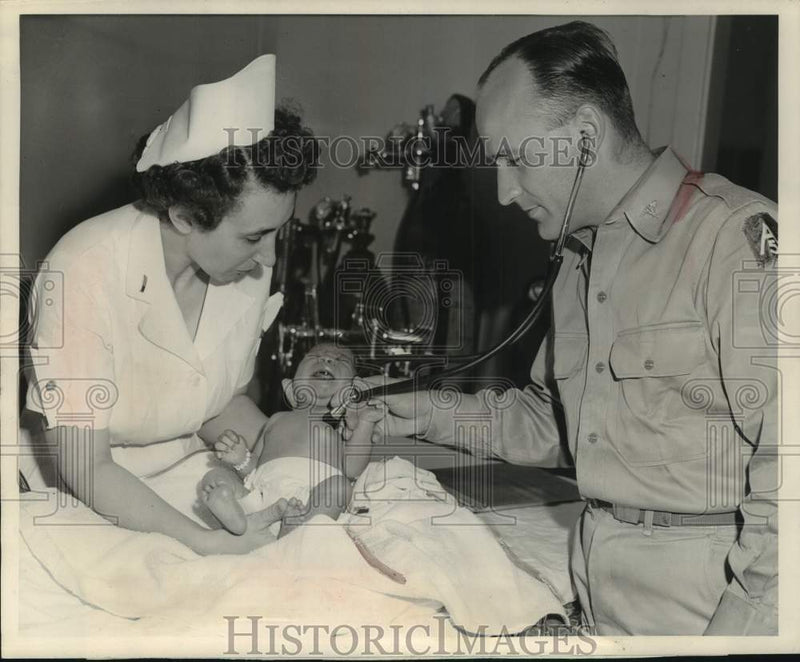 Load image into Gallery viewer, 1952 Press Photo Captain Graber (R) and Lieutenant Puffer with baby, Camp McCoy.
