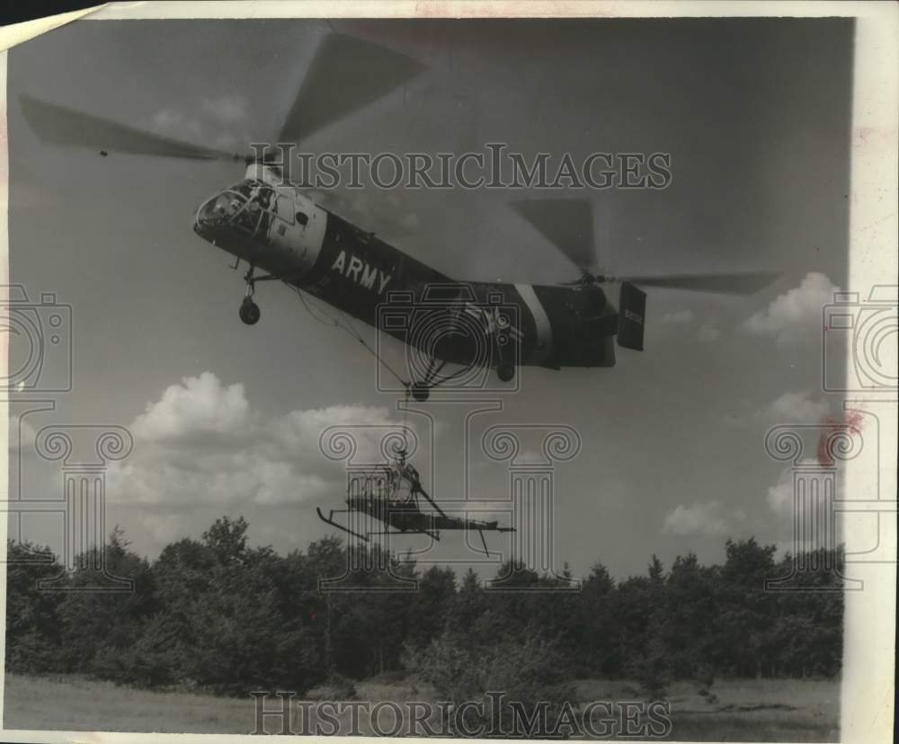 1962 Press Photo A cargo helicopter rescuing a disabled aircraft at Camp McCoy