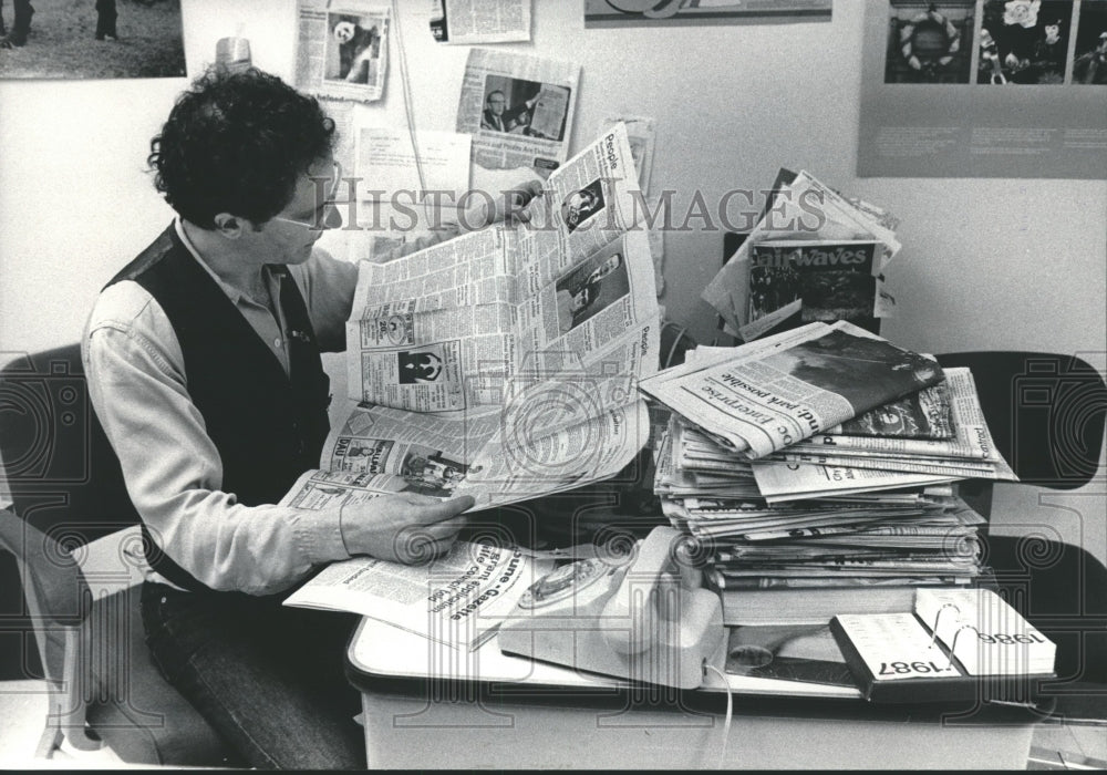 1985 Press Photo Wisconsin radio personality Michael Feldman reads newspapers.- Historic Images