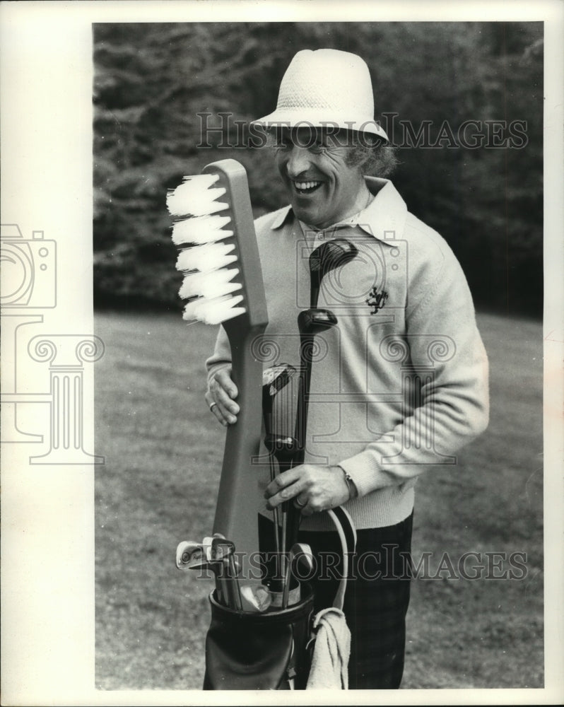 1976 Press Photo Comedian Bruce Forsyth with oversized toothbrush plays golf- Historic Images