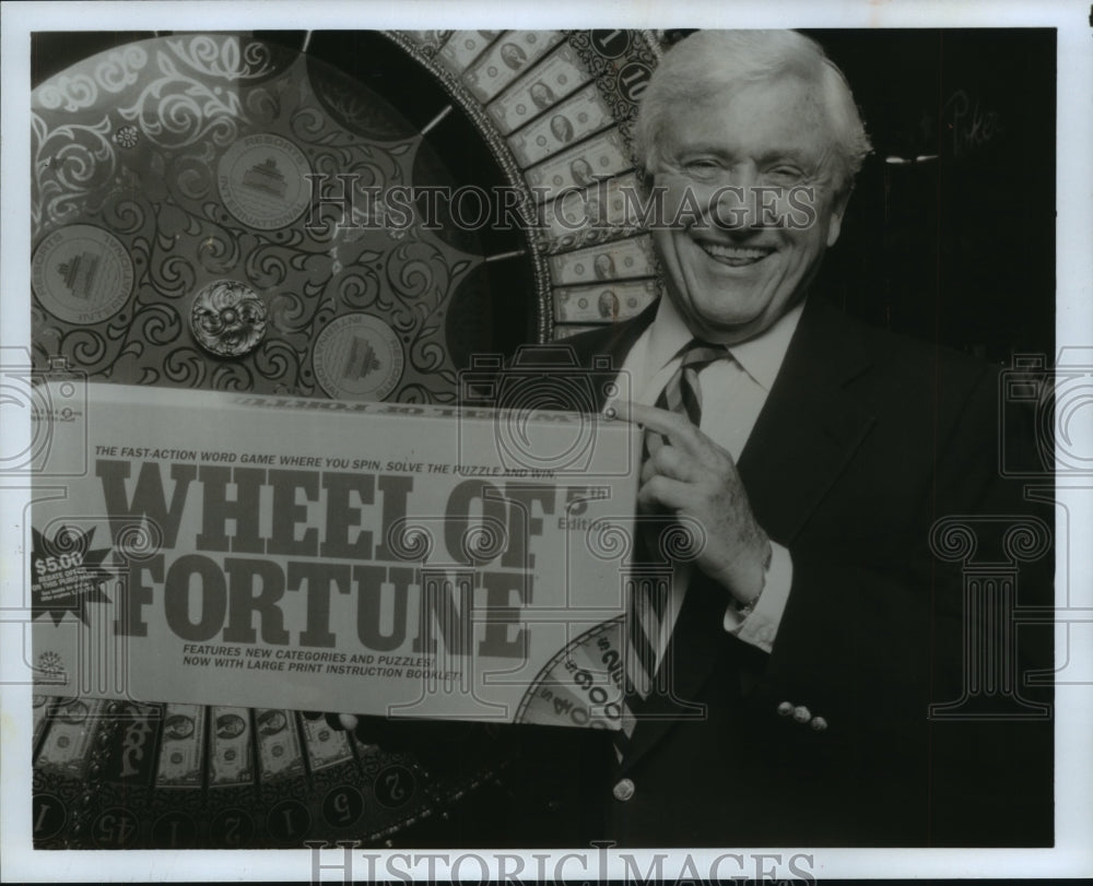 1991 Press Photo Merv Griffin, holding Wheel of Fortune game at ceremony, N.J.- Historic Images