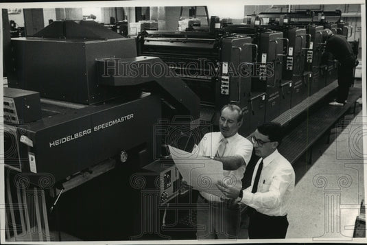 1988 Press Photo Serigraph, Incorporated Employees Look Over Game Card- Historic Images