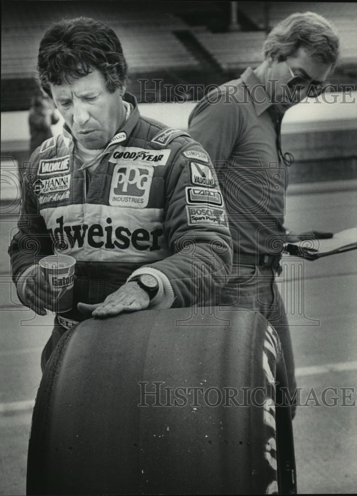 1983 Press Photo Mario Andretti checks tire at the Indianapolis 500 car race- Historic Images