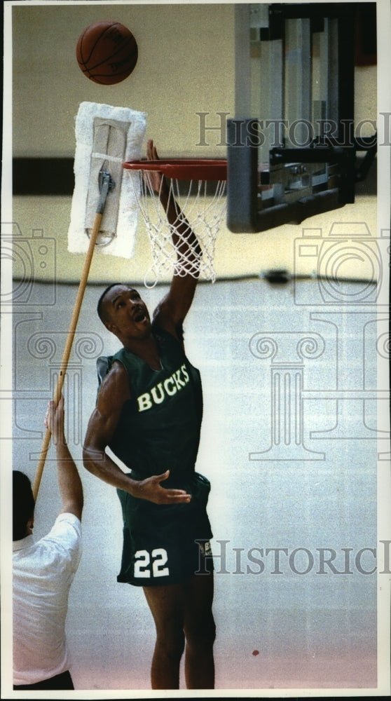 1993 Press Photo Ron Curry goes up against mop during Bucks basketball try outs- Historic Images