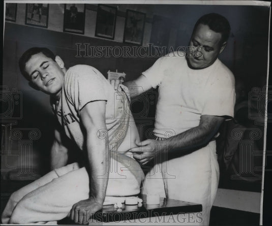 1953 Press Photo Minnesota football's Paul Giel assisted by trainer Lloyd Stein- Historic Images