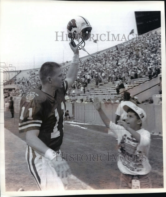 1995 Press Photo Young fan races for Darrell Bevell's helmet after football game- Historic Images
