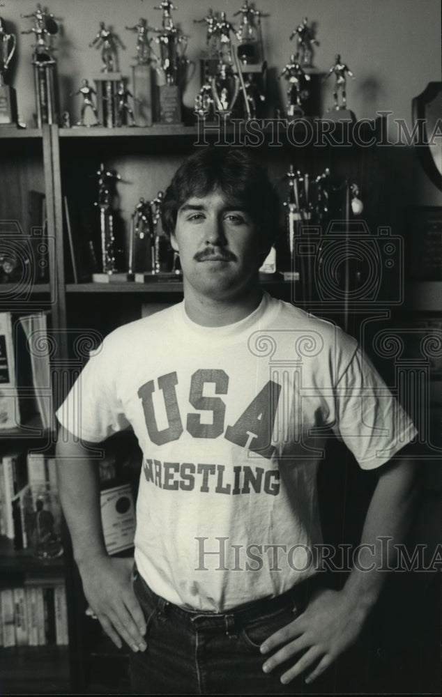 1986 Press Photo Wisconsin wrestler Brett Corner poses with trophies at home- Historic Images