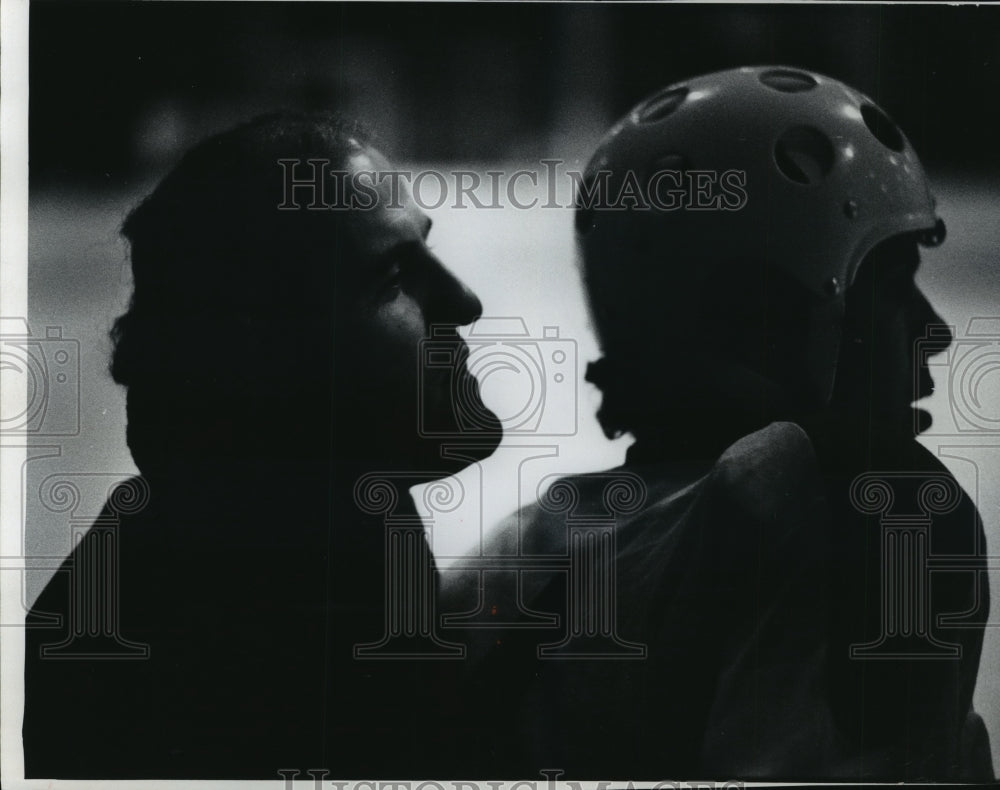 1976 Press Photo In silhouette Andre Caron instructs one of his players.- Historic Images