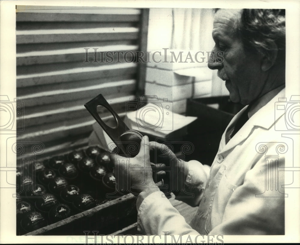 1987 Press Photo Craftsman Kenneth Munday Checks Size Of Newly Made Cricket Ball- Historic Images