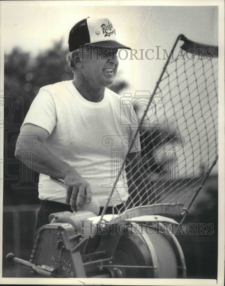 1985 Press Photo Bill Crisler, coach for Rice Lake putting balls in thrower.- Historic Images