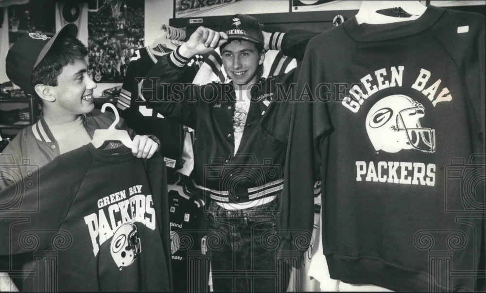 1989 Press Photo A Packers fan &amp; a Viking fan shop at Stadium Sports-Stuff store- Historic Images