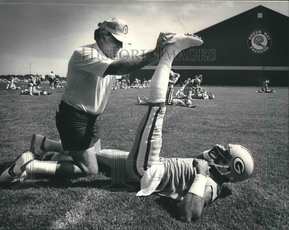 1984 Press Photo New Packer Coach Forrest Gregg helps Ron Cassidy stretch.- Historic Images