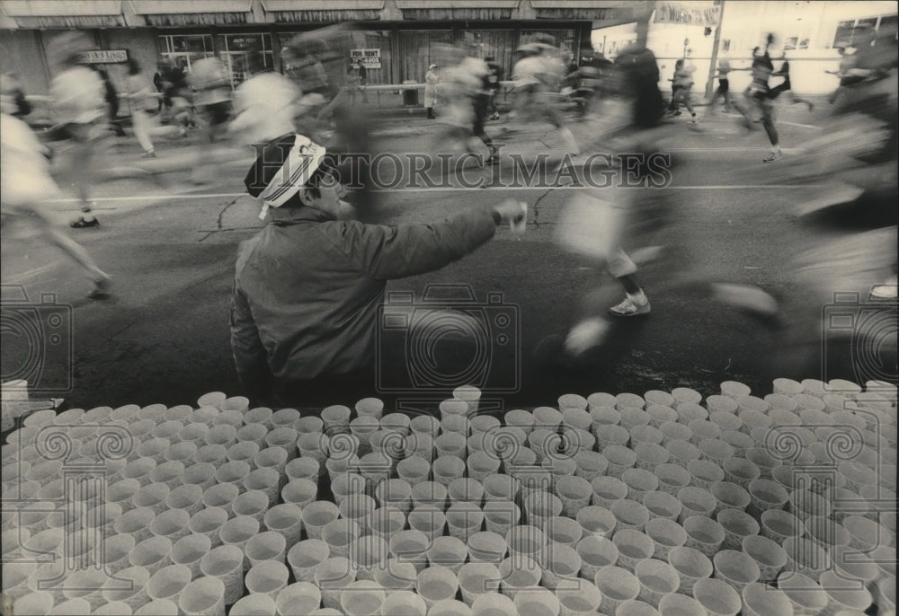 1984 Press Photo Boy hands out water to runners in Milwaukee&#39;s Al McGuire race- Historic Images