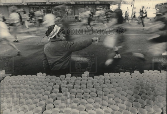 1984 Press Photo Boy hands out water to runners in Milwaukee's Al McGuire race- Historic Images
