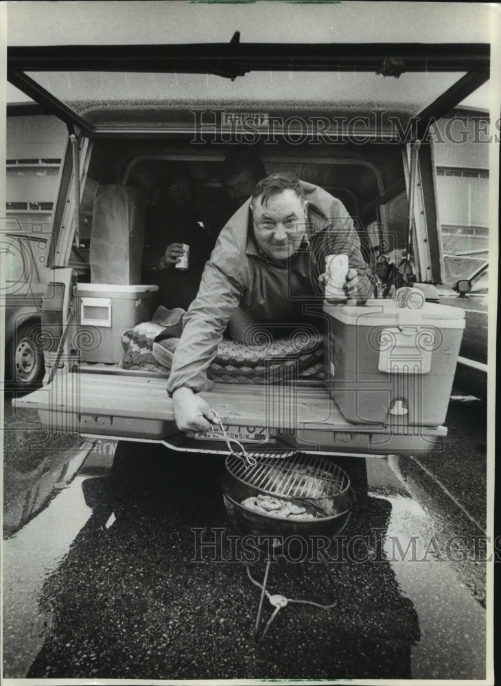 1982 Press Photo Tailgating Milton Dammer Stays out of Rain at County Stadium- Historic Images