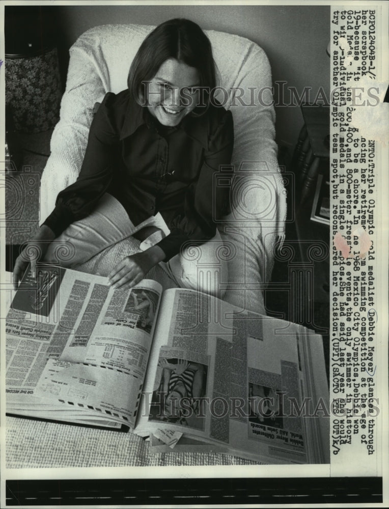 1972 Press Photo Olympic gold medalist Debbie Meyer glances through scrapbook.- Historic Images